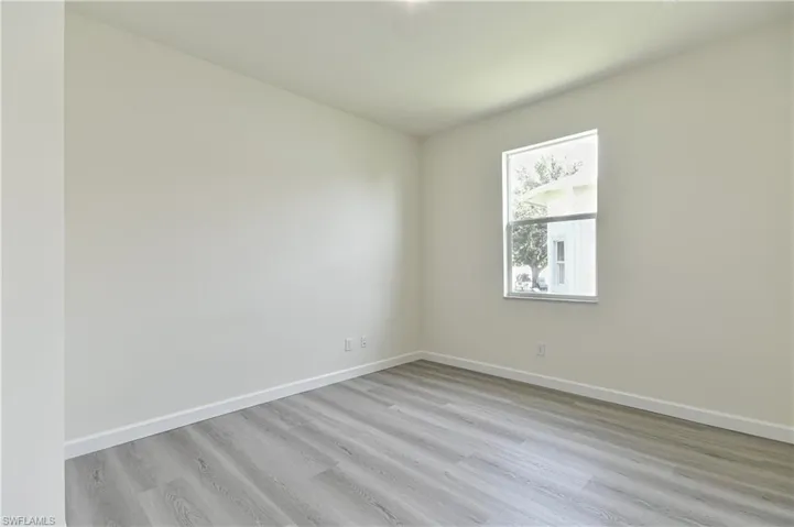 Unfurnished room featuring light wood-type flooring and baseboards