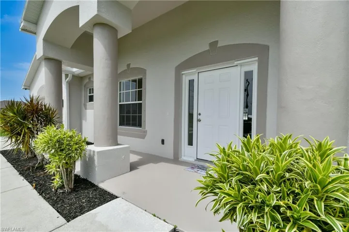 Property entrance with a porch and stucco siding