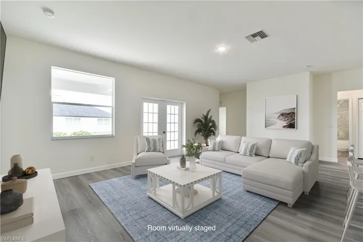 Living area with wood finished floors, french doors, and recessed lighting