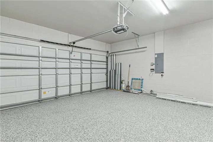 Garage featuring electric panel and a garage door opener