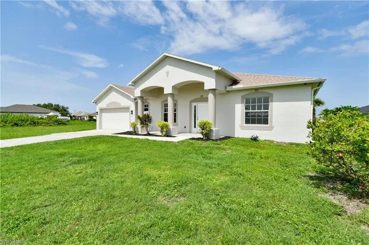 Ranch-style house with a front yard, concrete driveway, stucco siding, a shingled roof, and a garage
