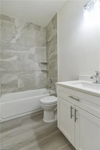 Full bath featuring vanity, tub / shower combination, and light wood-type flooring