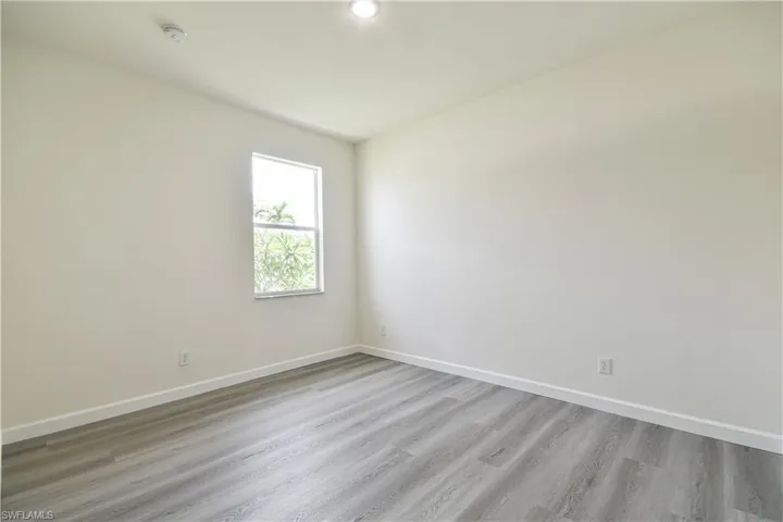 Spare room featuring light wood-type flooring and baseboards