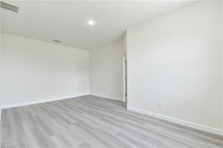Empty room with light wood-type flooring and baseboards