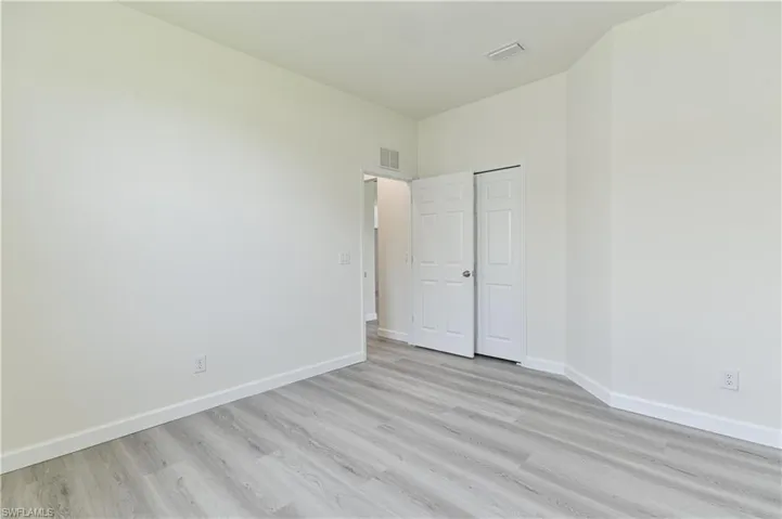 Empty room featuring baseboards and light wood-type flooring