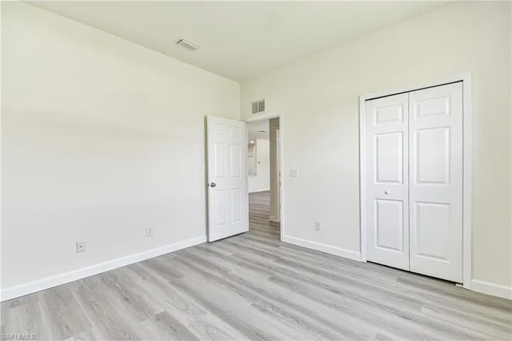Unfurnished bedroom with light wood finished floors and a closet