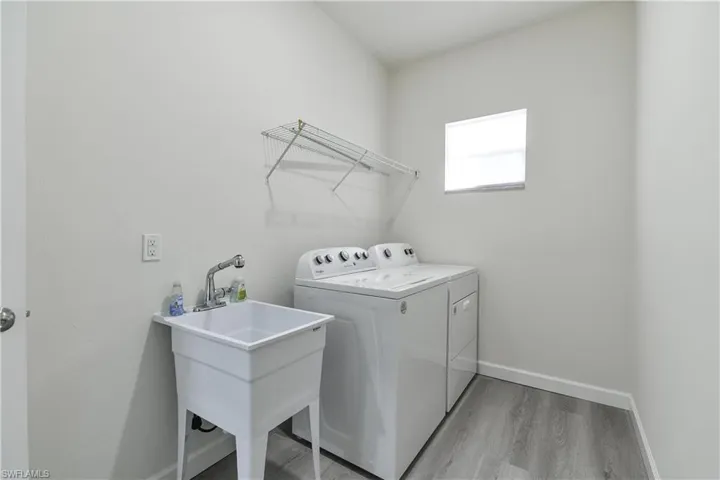 Laundry room featuring light wood-style flooring and washing machine and clothes dryer