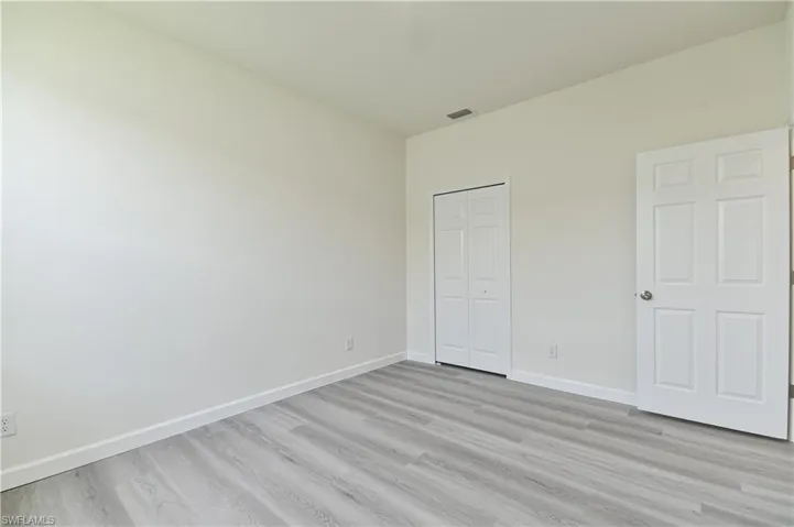 Unfurnished bedroom featuring light wood finished floors and a closet