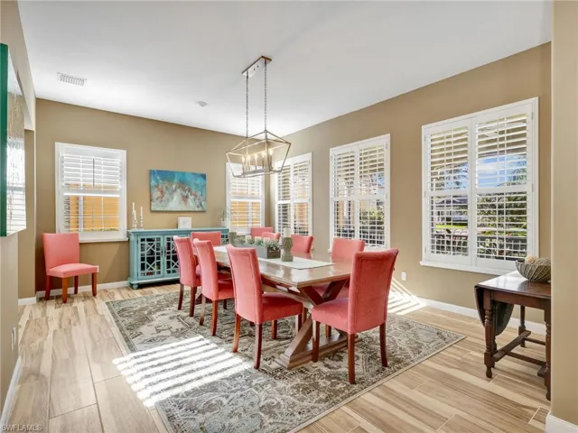 Dining space with light wood-style floors, healthy amount of natural light, and a chandelier