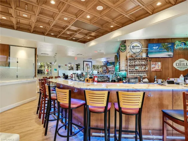 Community bar area featuring wooden walls, light countertops, an ornate ceiling, and recessed lighting