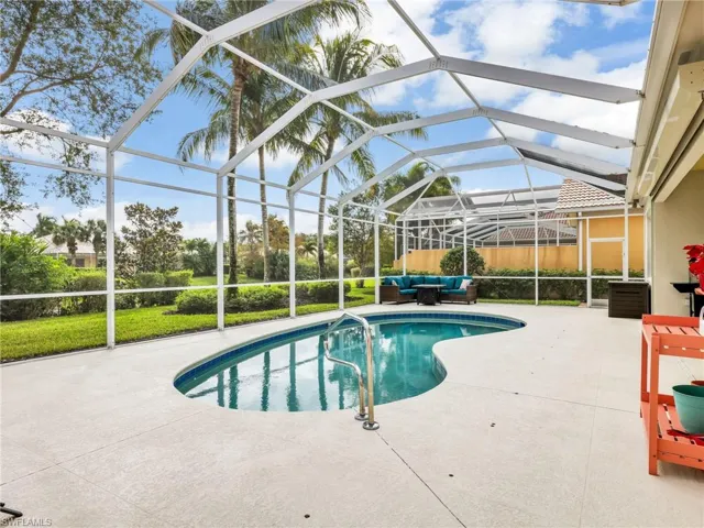 Outdoor pool with a sunroom, a patio area, and a lanai