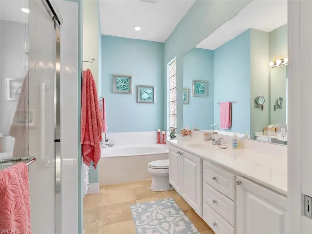 Full bathroom with vanity, a stall shower, a garden tub, and light tile patterned floors