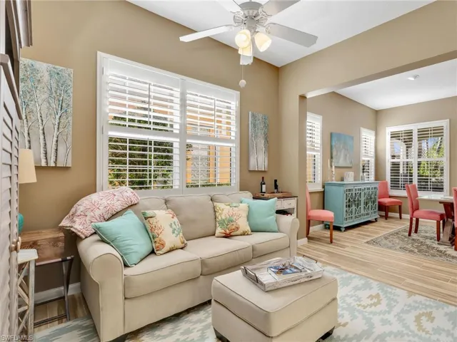Living room with healthy amount of natural light, wood finished floors, and ceiling fan