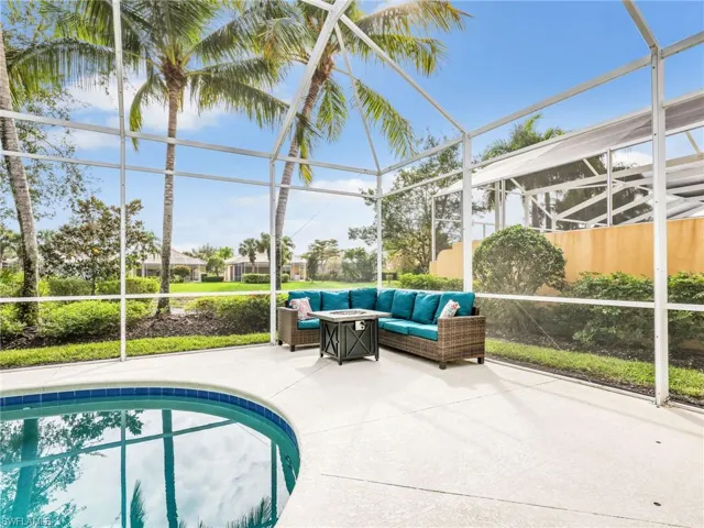 Outdoor pool featuring glass enclosure, a sunroom, and a patio area