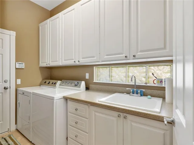 Laundry area featuring separate washer and dryer and cabinet space