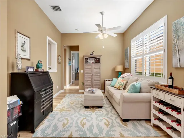 Living room with ceiling fan and light wood-style floors