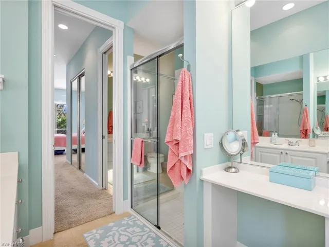 Bathroom with vanity, recessed lighting, light colored carpet, light tile patterned flooring, and a stall shower