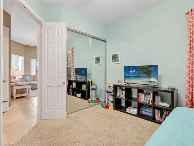 Carpeted bedroom featuring a closet and tile patterned floors