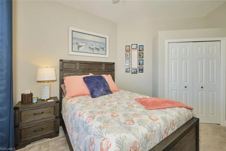 Bedroom with light colored carpet and a closet