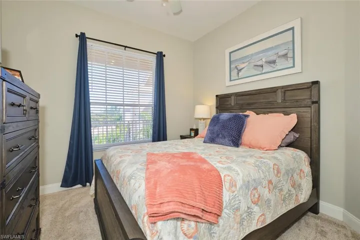Bedroom with a ceiling fan and light colored carpet