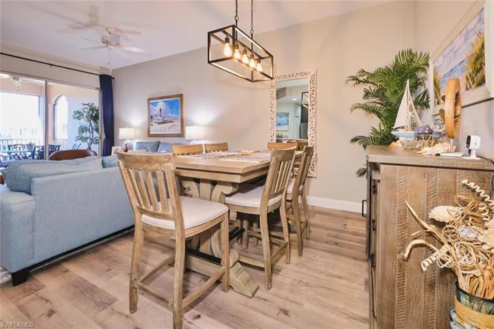 Dining space featuring light wood-type flooring, a ceiling fan, and suspended lighting