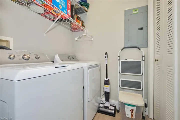 Laundry room with electric panel and washer and dryer