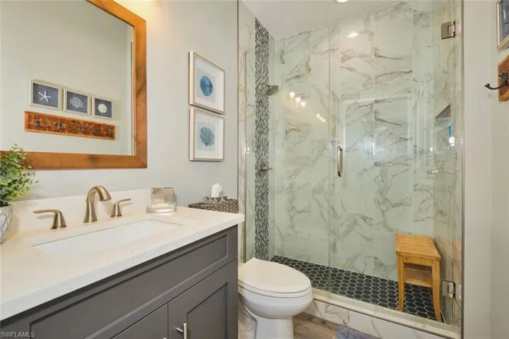 Bathroom with a marble finish shower and vanity