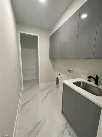 Laundry area with washer hookup, cabinets, sink, and electric dryer hookup