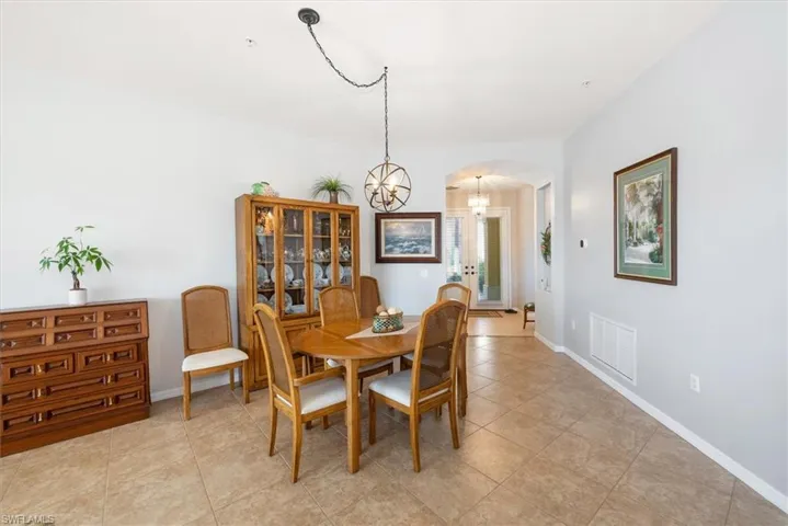 Dining area featuring light tile patterned flooring and a chandelier