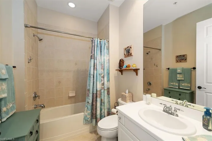 2nd Bathroom with corian vanity, shower / bath combination with curtain, and light tile patterned flooring