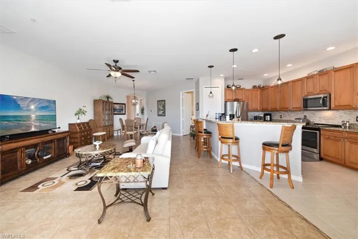 Living area with light tile patterned floors, recessed lighting, and ceiling fan