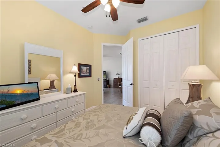 Bedroom with a closet, ceiling fan, and tile patterned floors