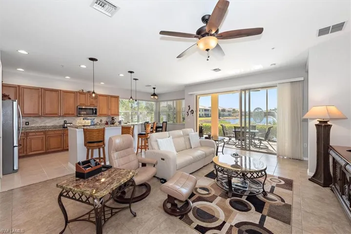 Living area with light tile patterned flooring, recessed lighting, a ceiling fan, and a water view