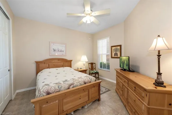 Bedroom with a closet, a ceiling fan, and light tile patterned flooring