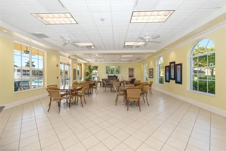 Clubhouse dining space featuring ceiling fan, light tile patterned floors, a paneled ceiling, and crown molding