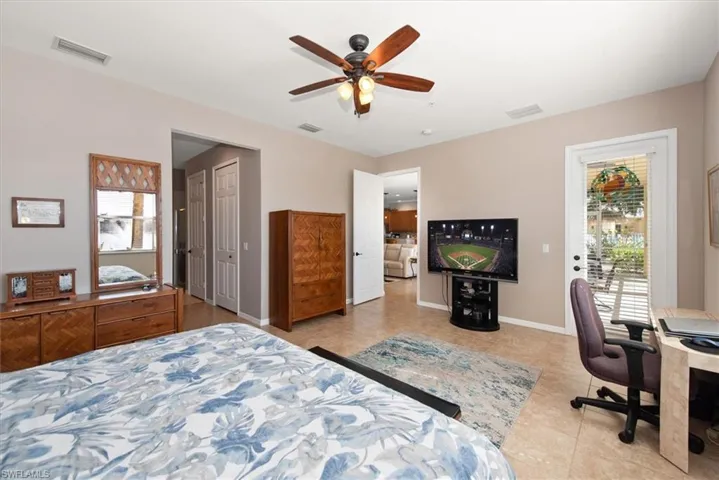 Bedroom with access to outside, a desk, light tile patterned floors, a ceiling fan, and a closet