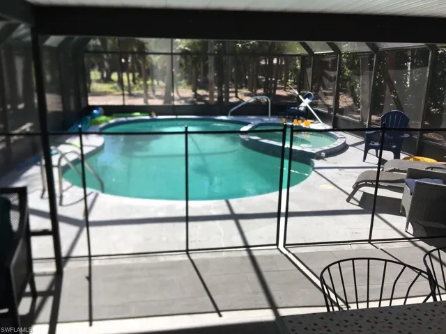 View of swimming pool with a sunroom, a pool with connected hot tub, a lanai, and a patio area