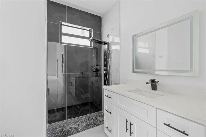 Bathroom with a shower with door and vanity