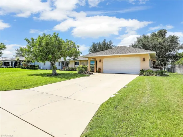 Ranch-style home featuring a garage and a front lawn