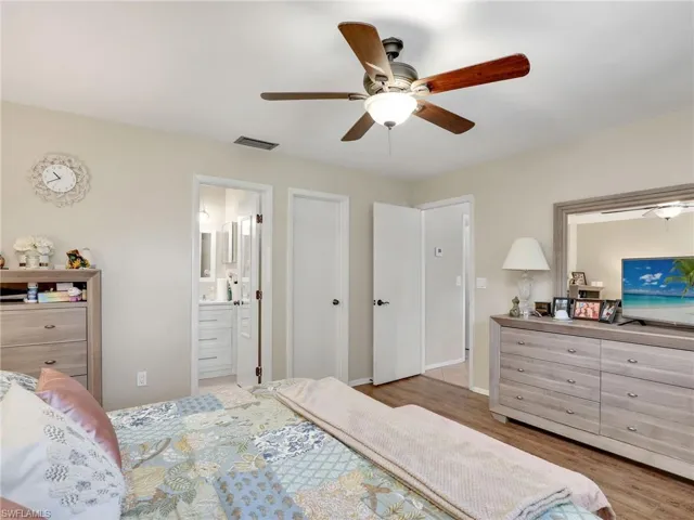 Bedroom featuring ceiling fan, connected bathroom, and light hardwood / wood-style flooring