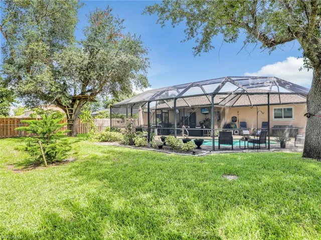 Back of property with a yard, a patio area,  and a fenced in pool