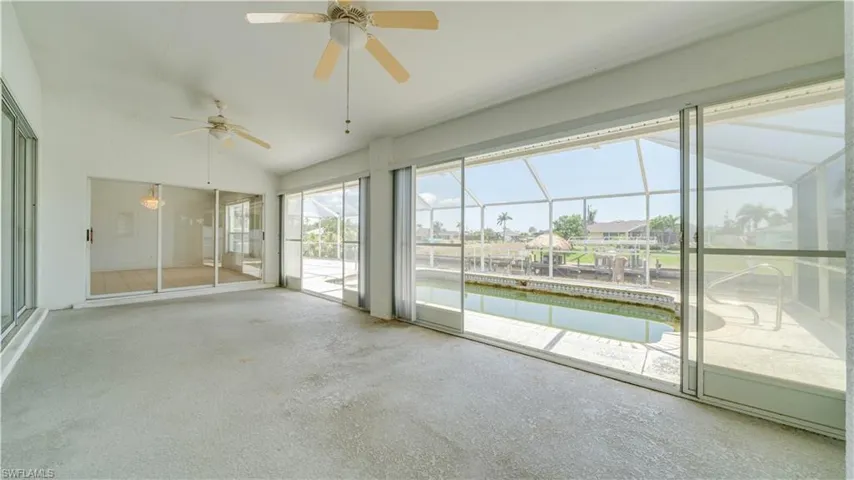 Florida room with sliders out to caged pool.