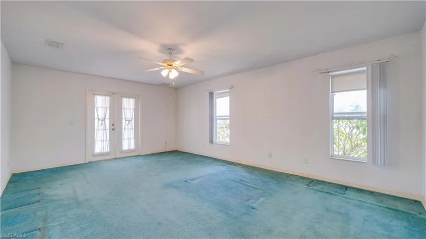 Primary bedroom with French doors leading to the Florida room.