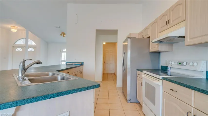 Kitchen showing walkway through hall to the laundry room leading out to the garage. Two guest bedrooms & bathroom are down the hall to the right.