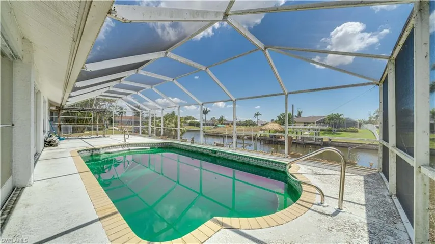 Outdoor pool with all new screens in pool cage, and view of the Gulf Access Canal.