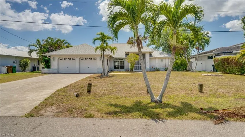 Ranch-style house with a large front lawn and an attached garage.