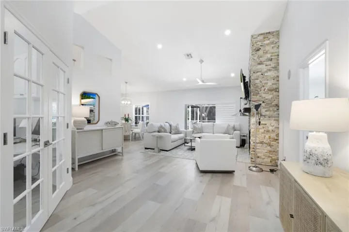 Living room featuring light hardwood / wood-style flooring, french doors, and high vaulted ceiling