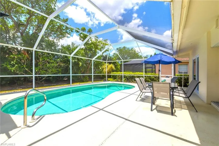 Swimming pool featuring a patio area, outdoor dining area, and glass enclosure