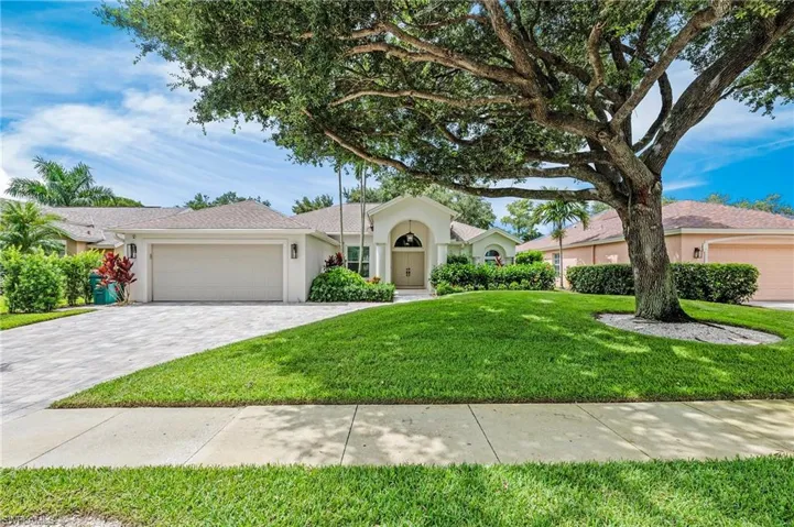 View of front of house with a garage and a front yard