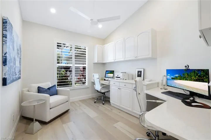 Home office with light hardwood / wood-style floors, vaulted ceiling, and ceiling fan